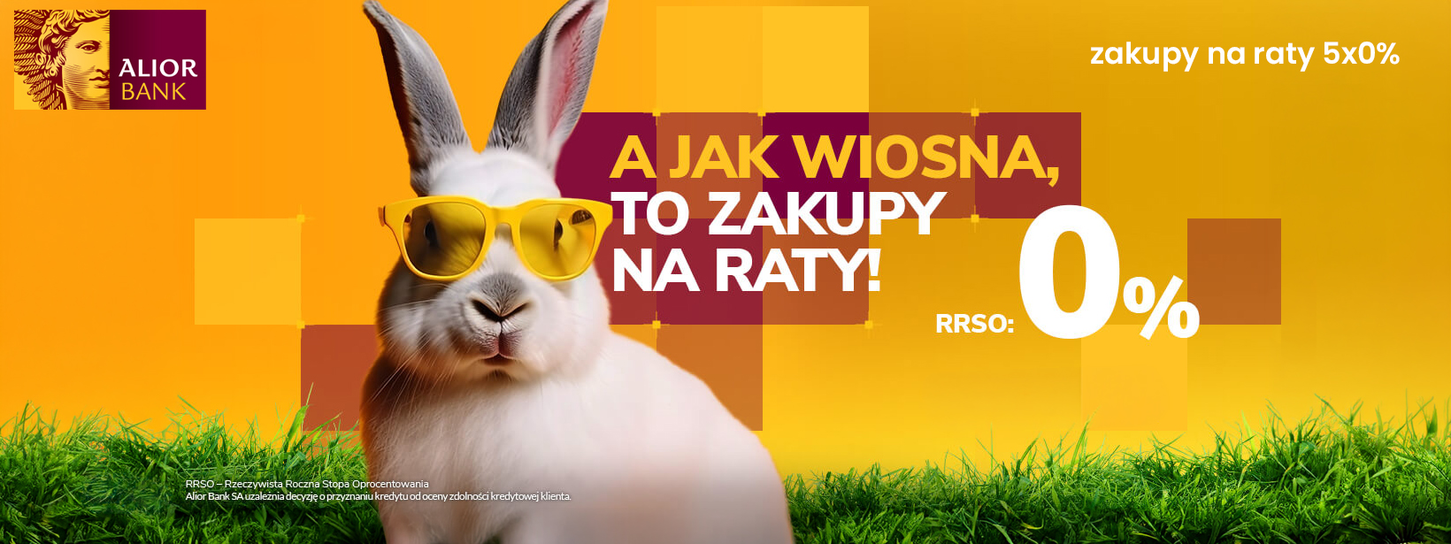 Baner Alior Banku z białym królikiem w żółtych okularach na tle pomarańczowych kwadratów i zielonej trawy. Napisy informują o zakupach na raty 5x0% oraz RRSO 0%. W rogu widoczne jest bordowo-złote logo banku.