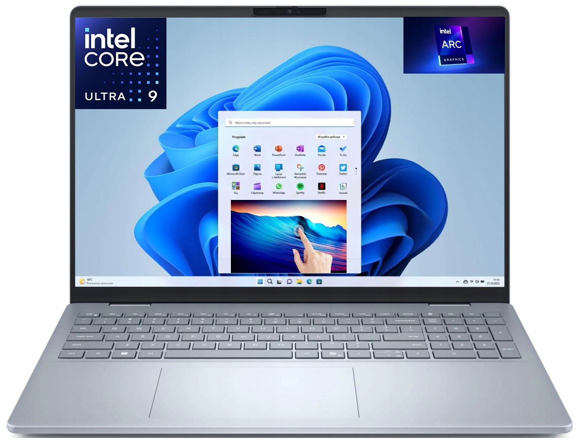 Srebrzystoszary laptop przedstawiony na białym tle, widok od przodu z otwartym ekranem. Na wyświetlaczu widoczny jest system Windows 11 z niebieską tapetą i otwartym menu Start. W lewym górnym rogu ekranu umieszczono duże logo intel CORE ULTRA 9, a w prawym górnym rogu logo intel ARC GRAPHICS. Urządzenie ma jasną klawiaturę z blokiem numerycznym, duży gładzik poniżej oraz kamerkę internetową nad ekranem.