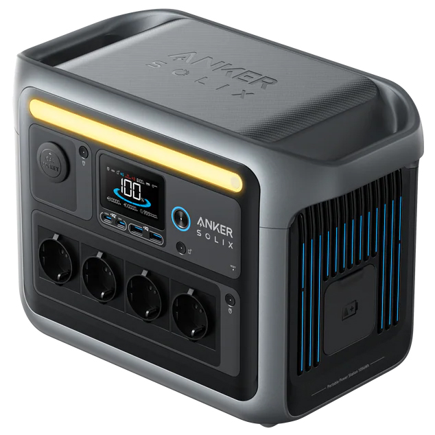 Stacja zasilania Anker SOLIX C1000 w czarno-szarej obudowie, pokazana z kompletem kabli zasilających i solarnych oraz instrukcją. Urządzenie posiada wbudowany ekran, oświetlenie LED oraz liczne porty USB i gniazda AC, oferując wszechstronne możliwości ładowania w terenie.