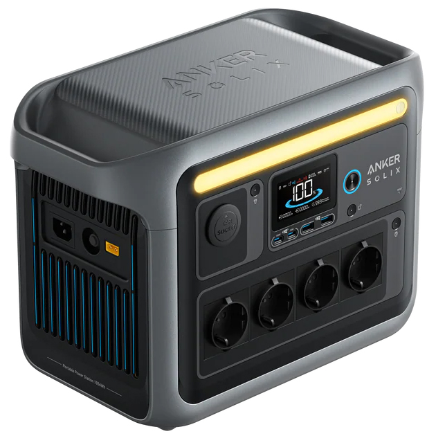 Stacja zasilania Anker SOLIX C1000 w widoku bocznym, prezentującym porty wejściowe do ładowania (sieciowe i solarne). Urządzenie posiada nowoczesną konstrukcję z czytelnym wyświetlaczem, czterema gniazdami AC i zintegrowanymi uchwytami do przenoszenia. Kolorystyka to połączenie grafitu, czerni i niebieskich akcentów.