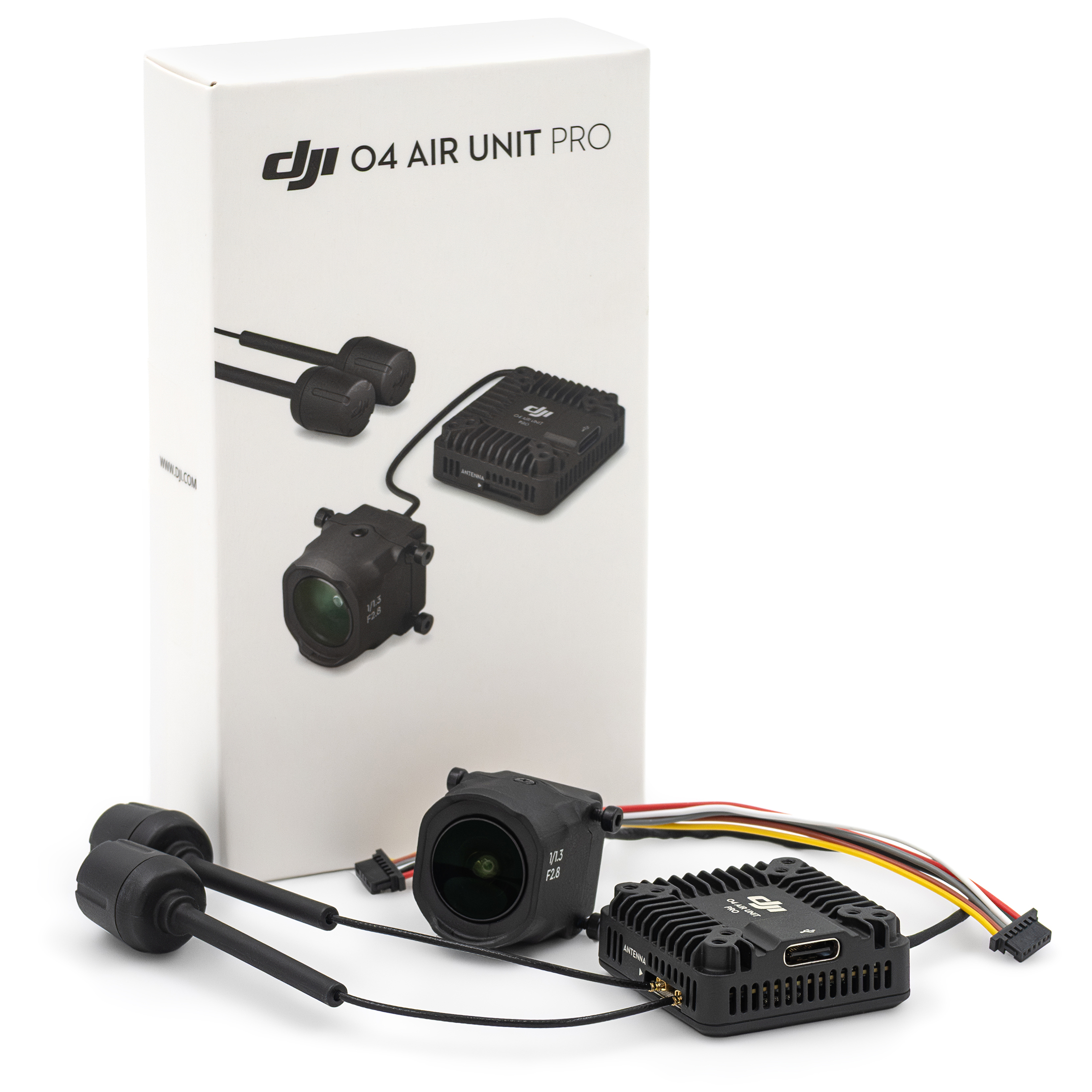 System transmisji DJI O4 Air Unit Pro wraz z białym opakowaniem, pokazany od przodu na białym tle. Przed pionowo ustawionym pudełkiem wyeksponowano czarny żebrowany moduł z portem USB-C, niewielką kamerę z oznaczeniem jasności obiektywu, dwie czarne anteny oraz wiązkę wielokolorowych przewodów.