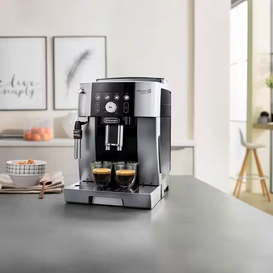 Ekspres DeLonghi Magnifica S Smart w aranżacji kuchennej z dwiema kawami espresso. Zdjęcie pokazuje urządzenie na blacie w jasnym, nowoczesnym wnętrzu, podkreślając jego estetykę i funkcjonalność w domowym zaciszu.