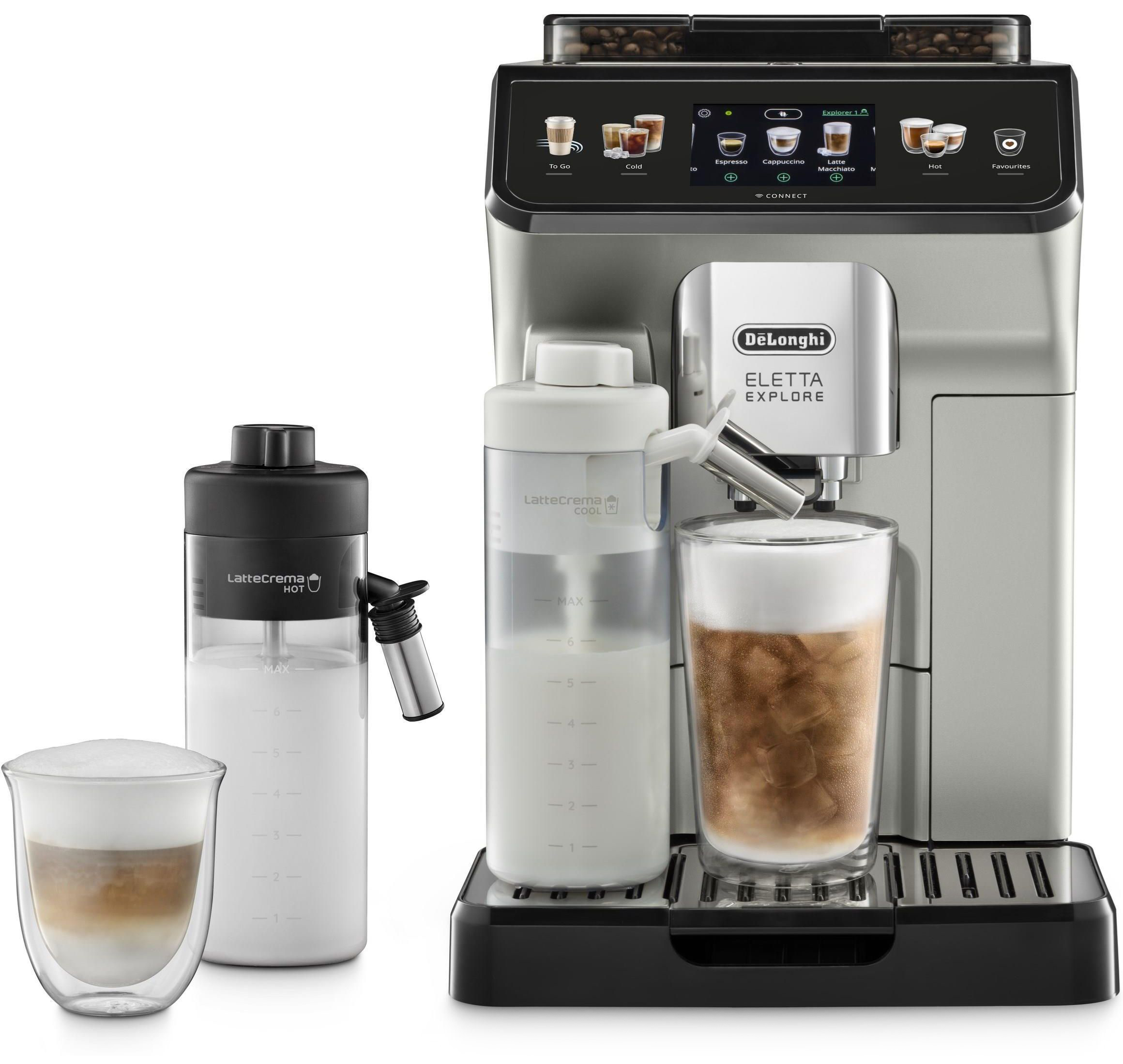 Srebrny ekspres DeLonghi Eletta Explore z dwiema karafkami na mleko i dwiema szklankami kawy na białym tle. Urządzenie ma kolorowy wyświetlacz i przygotowuje mrożoną kawę w wysokiej szklance.