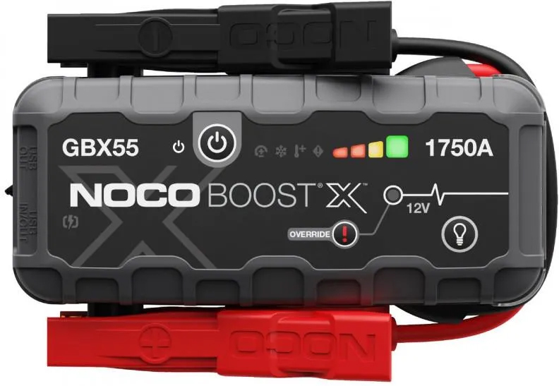 Urządzenie rozruchowe NOCO Boost X GBX55 z czerwonym i czarnym zaciskiem, widok od frontu na białym tle. Na panelu widoczne jest logo marki, wskaźnik naładowania LED, ikona latarki oraz przycisk trybu Override.