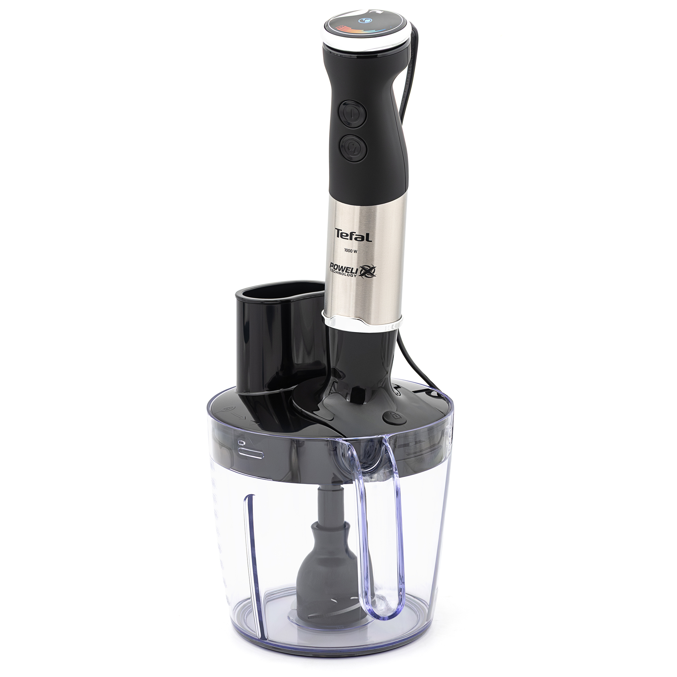 Przezroczysta misa malaksera do blendera Tefal Quickchef+ HB67G830 na białym tle. Widok na czarną pokrywę z dwoma kominkami wlotowymi, przezroczysty uchwyt oraz zamontowane wewnątrz dno z ostrzem tnącym.