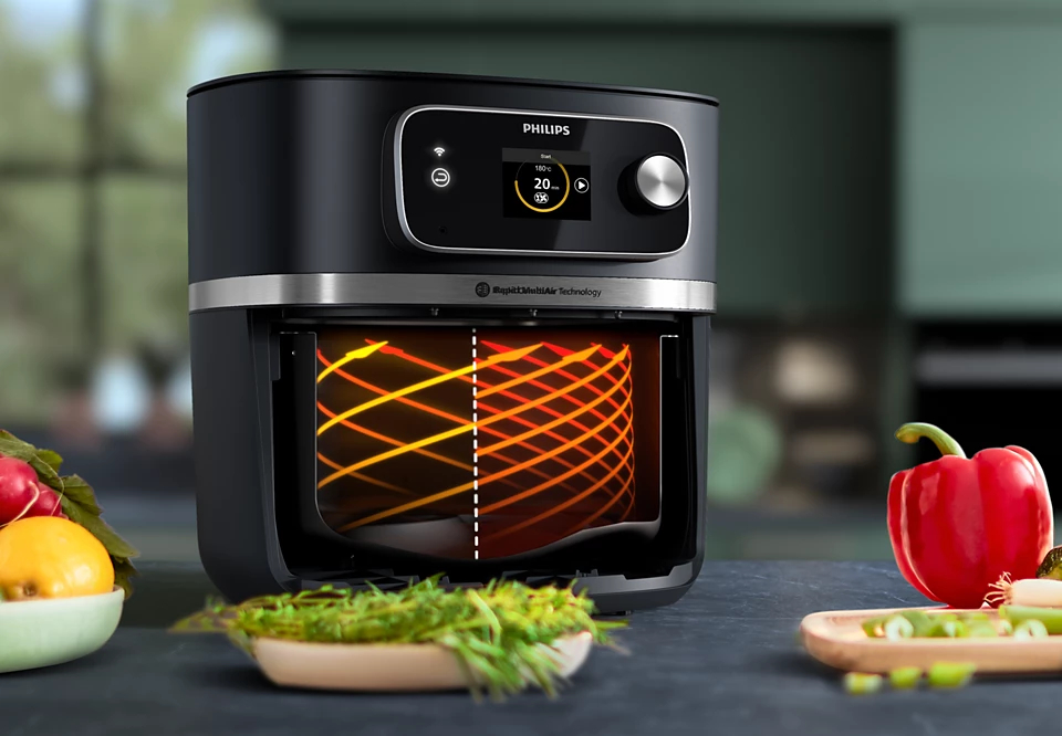 Frytownica beztłuszczowa Philips Airfryer Combi XXL z wizualizacją przepływu powietrza i świeżymi warzywami.