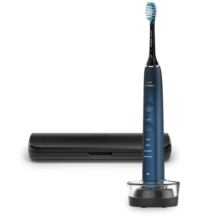 Granatowa szczoteczka Philips Sonicare 9000 DiamondClean w szklanej ładowarce, obok czarnego etui podróżnego. Szczoteczka posiada podświetlany panel z trybami pracy i czarną końcówkę wymienną. Widok z przodu na białym tle.