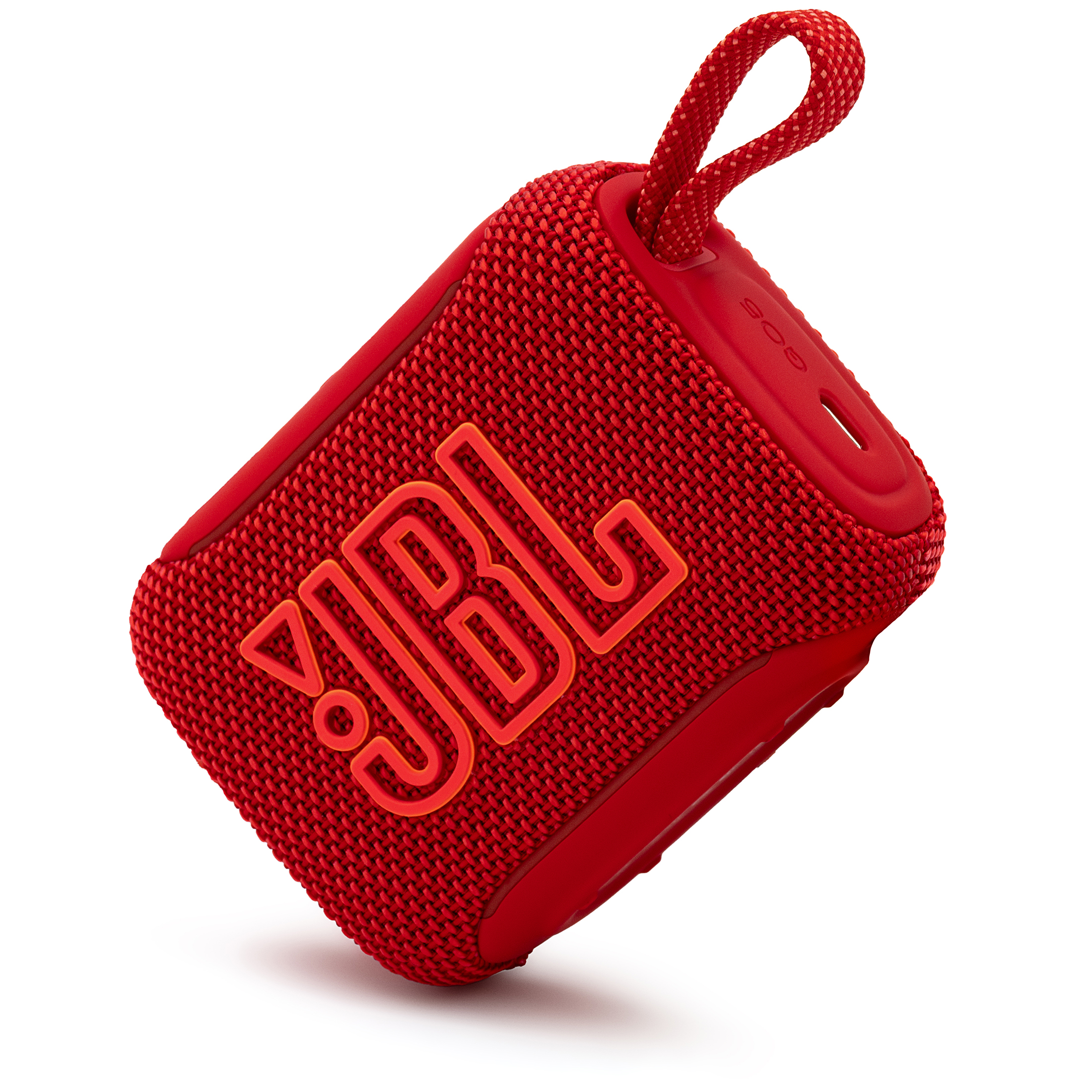 Czerwony głośnik przenośny JBL Go 5, przedstawiony pod kątem w pozycji pochylonej na białym tle. Dynamiczny kadr eksponuje duże logo frontowe z pomarańczową obwódką, plecioną strukturę materiału oraz boczny panel z napisem GO5, portem USB-C i uniesioną pętlą ze sznurka.