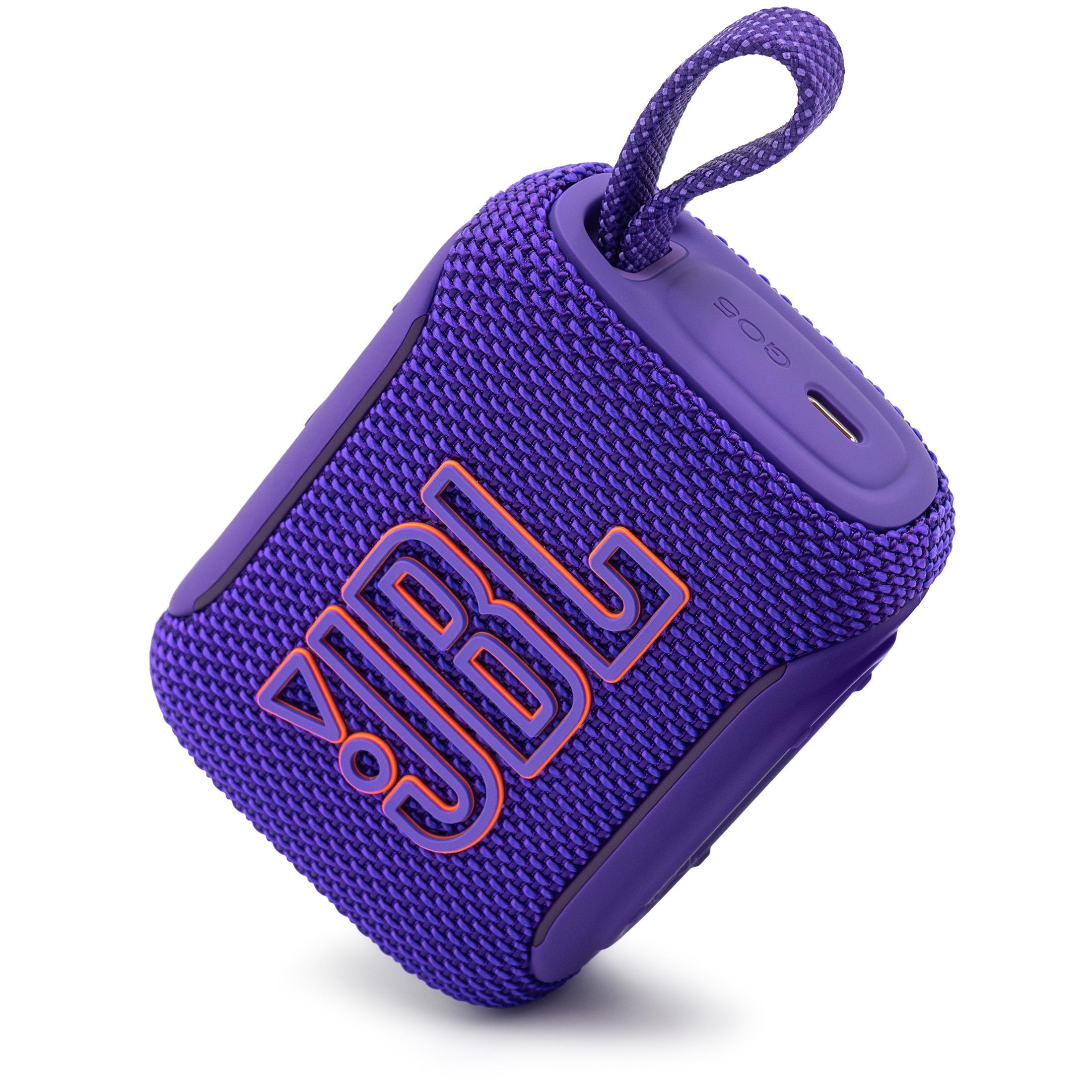 Fioletowy głośnik przenośny JBL Go 5, przedstawiony pod kątem w pozycji pochylonej na białym tle. Dynamiczny kadr eksponuje duże logo frontowe z pomarańczową obwódką, plecioną strukturę materiału oraz boczny panel z napisem GO5, portem USB-C i uniesioną pętlą ze sznurka.