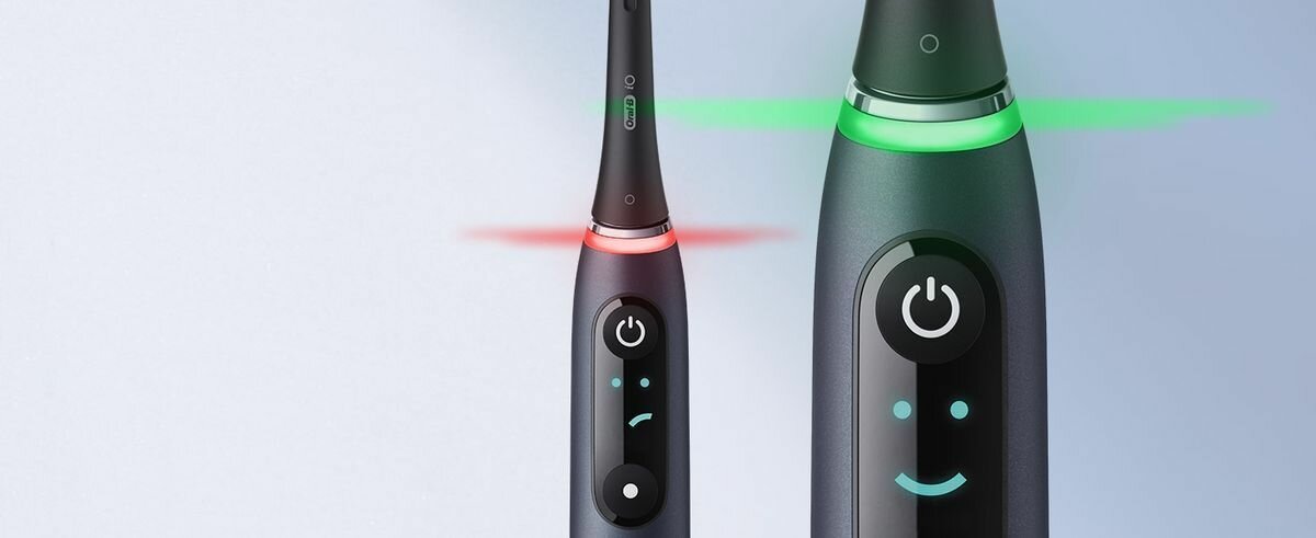 Zbliżenie na rączkę szczoteczki Oral-B iO Series 9 Special Edition pokazujące działanie czujnika nacisku z czerwonym światłem ostrzegawczym oraz zielonym światłem prawidłowego szczotkowania.