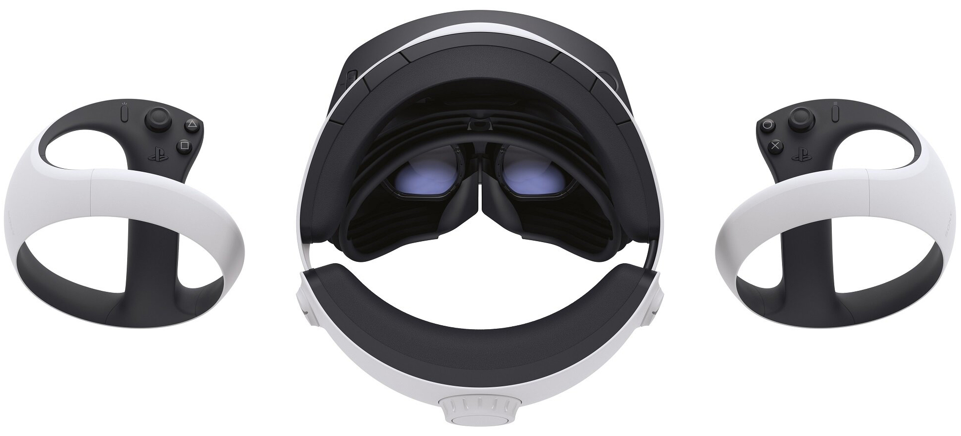 Gogle wirtualnej rzeczywistości Sony PlayStation VR2 oraz dwa kontrolery Sense na białym tle, widok z góry i od tyłu konstrukcji. Perspektywa ta pozwala zobaczyć wnętrze gogli, w tym dwie zaokrąglone soczewki z niebieskawym odblaskiem oraz profilowaną czarną osłonę gumową. Kontrolery są ustawione symetrycznie po lewej i prawej stronie, prezentując czarne panele sterowania z przyciskami.