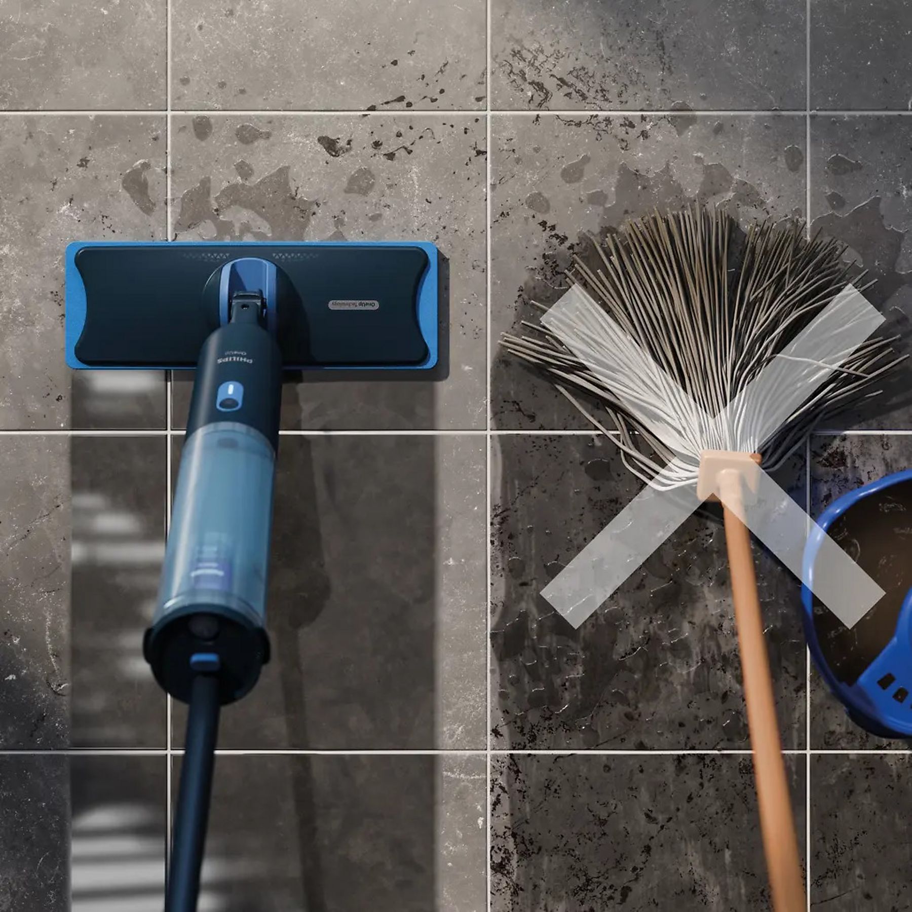 Korpus i głowica mopa elektrycznego Philips OneUp XV3101/01 leżące na ciemnych, marmurkowych płytkach. Obok, po prawej stronie, widoczna jest tradycyjny mop, co sugeruje porównanie metod czyszczenia.