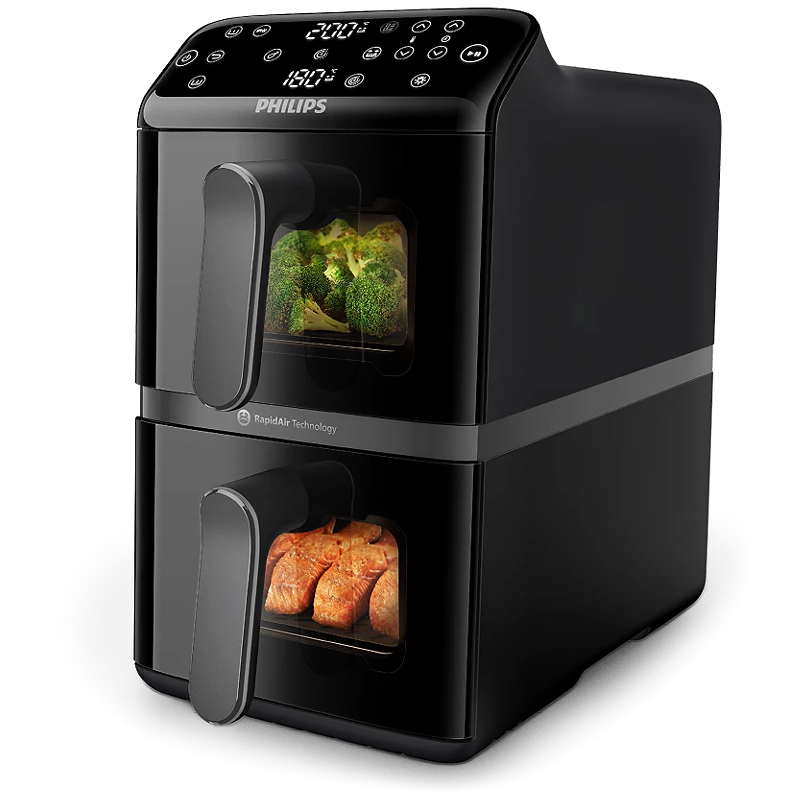 Frytkownica Philips Airfryer Dual Basket w kolorze czarnym. Urządzenie posiada dwie komory z okienkami podglądu, w których widać przyrządzane warzywa i rybę. Na górze znajduje się cyfrowy panel sterowania z wyświetlaczem temperatury i czasu dla obu stref gotowania.