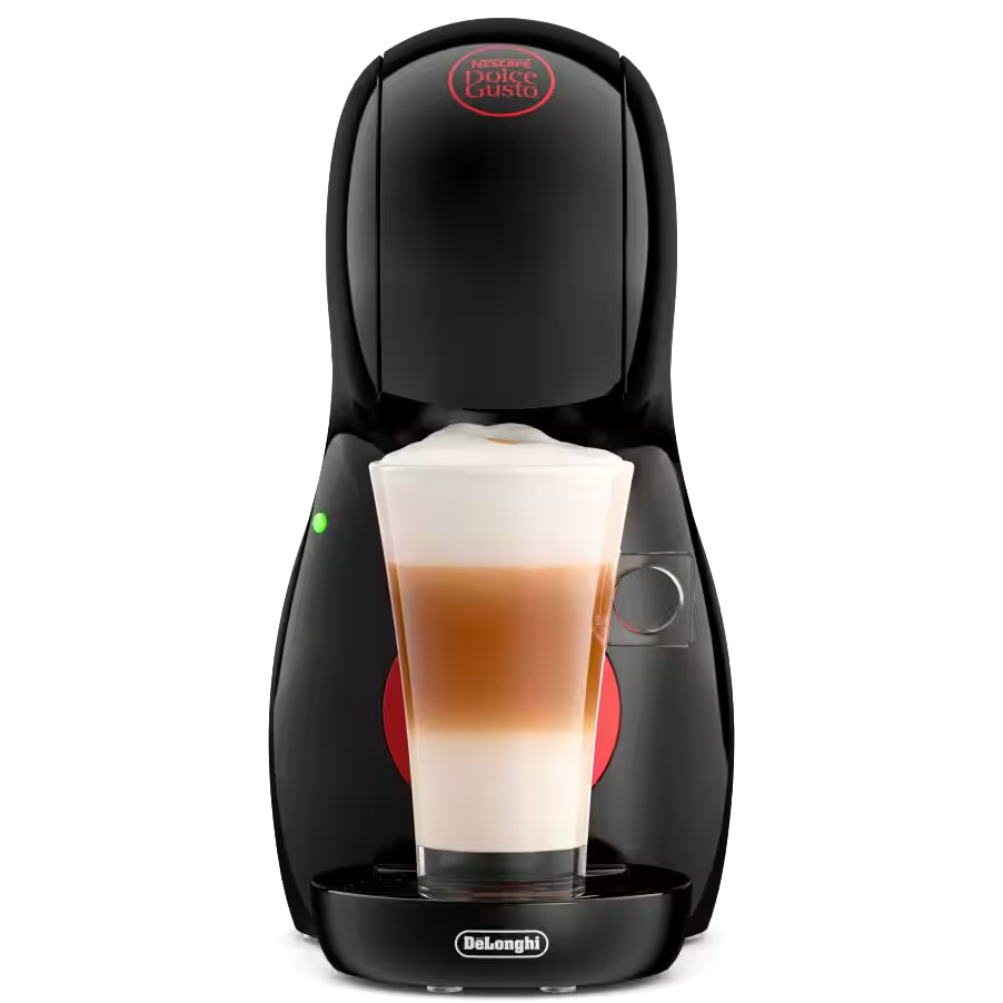 Czarny, lśniący ekspres kapsułkowy DeLonghi Piccolo XS z przygotowaną kawą latte w wysokiej szklance. Urządzenie o nowoczesnym, obłym kształcie z czerwonym logo na górze i zieloną lampką kontrolną z boku. Widok z przodu na białym tle.
