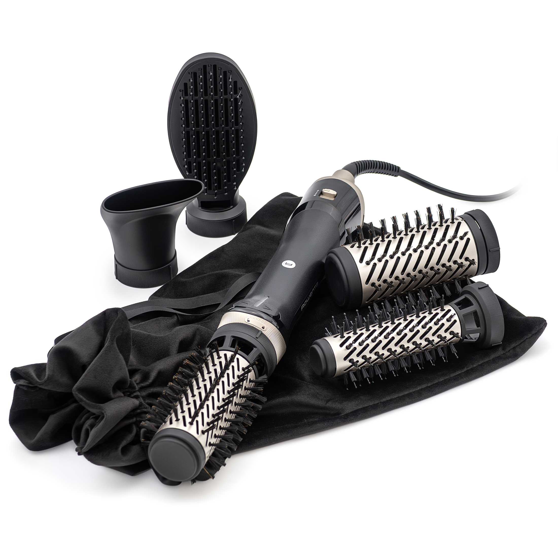 Czarna lokówko-suszarka Rowenta Brush Activ leżąca na czarnym etui wraz z czterema wymiennymi końcówkami. Zestaw obejmuje trzy szczotki różnego typu oraz koncentrator, ukazane na białym tle. Widok z perspektywy bocznej prezentuje urządzenie gotowe do pracy oraz dodatkowe akcesoria.